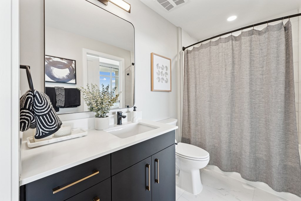 A bathroom with a white counter top and a white toilet.