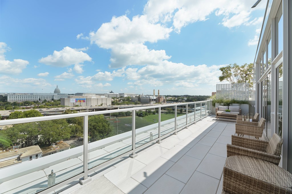 A balcony with chairs and a view of a cityscape.