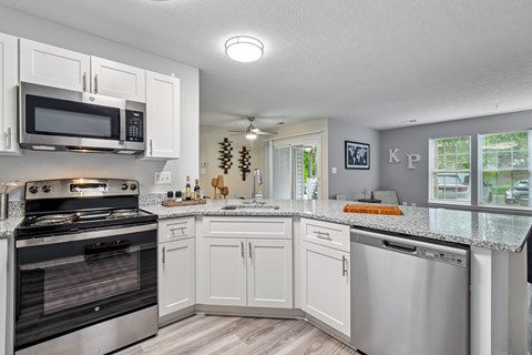 A kitchen with white cabinets and a black stove top oven.