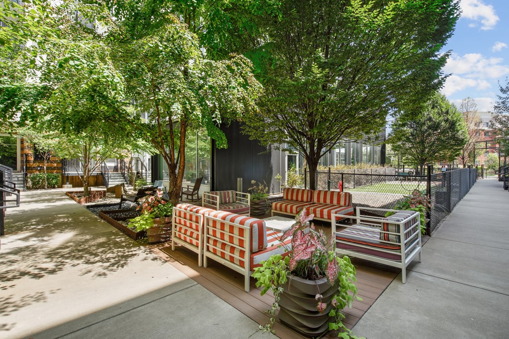 A patio with a white bench and a striped cushion.