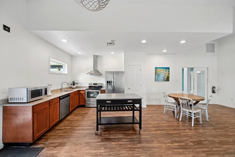 A kitchen with wooden floors and a dining table.