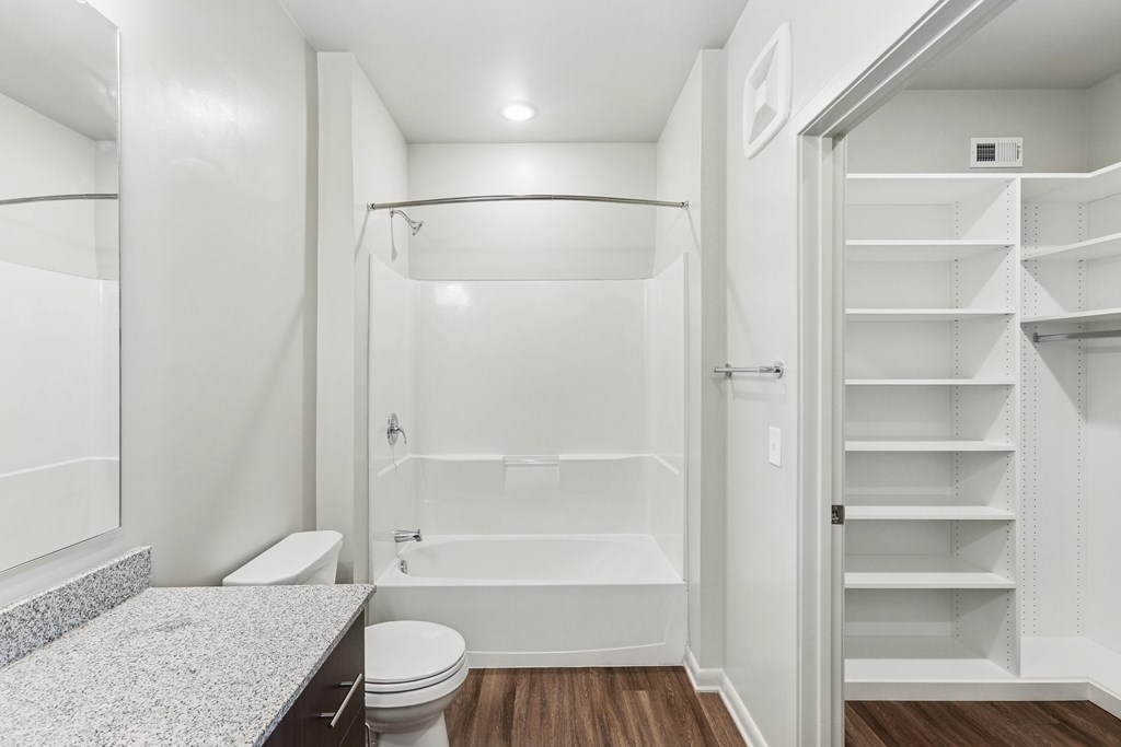 A white bathroom with a walk-in shower and a toilet.