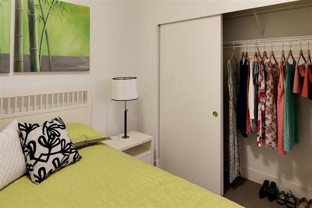 a bedroom with a yellow bed and a closet