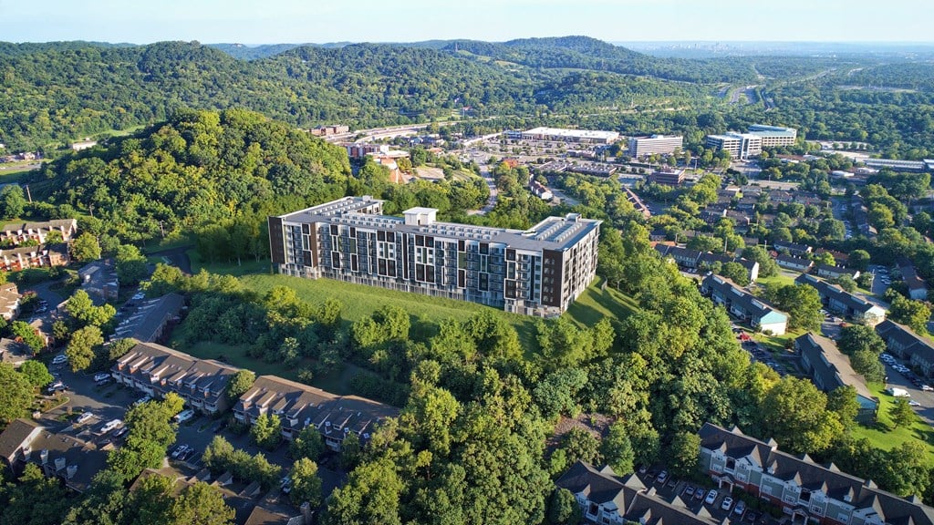 A large building surrounded by trees is in the center of a town.