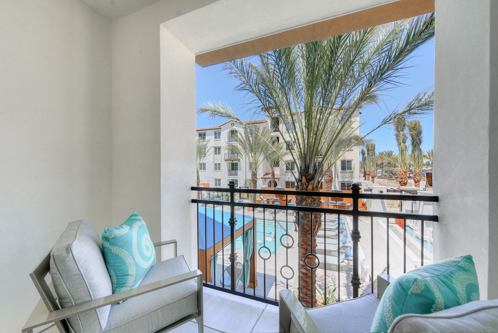 Living room with a balcony overlooking a pool and palm trees at Sola, San Diego, 92130