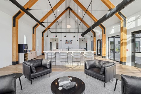 a large living room with leather furniture and a kitchen with a large table and chairs