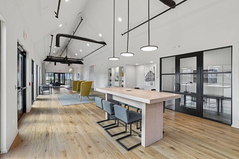 a communal area with a large table and chairs in a room with glass doors