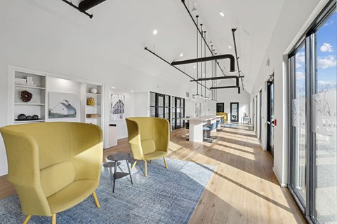 a lobby with yellow chairs and a blue rug