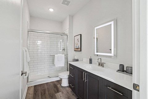 a white and black bathroom with a shower and sink