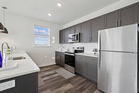 a kitchen with stainless steel appliances and gray cabinets