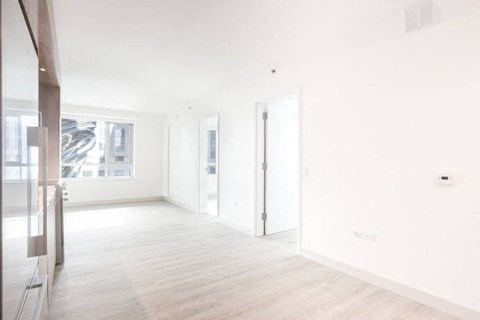 an empty room with white walls and wood floors