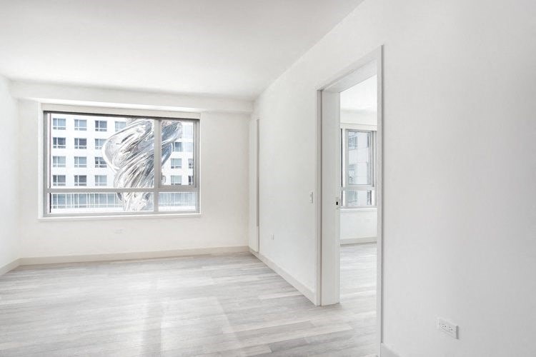 a bedroom with hardwood floors and a large window