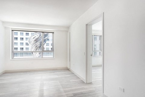 a bedroom with hardwood floors and a large window
