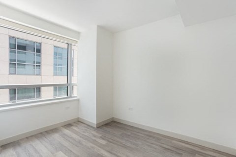 an empty room with a large window and white walls