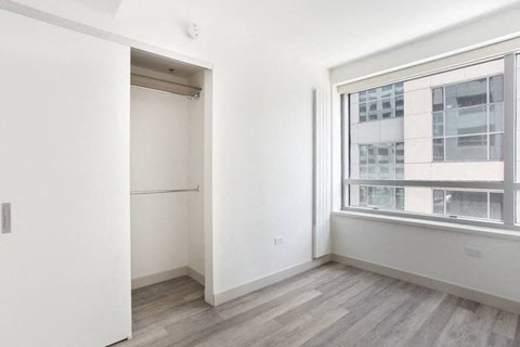 an empty room with a large window and white walls