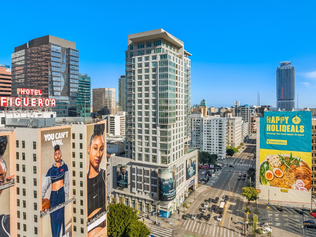 A cityscape with a Hotel Figueroa and a billboard for Kaffi Holidays.