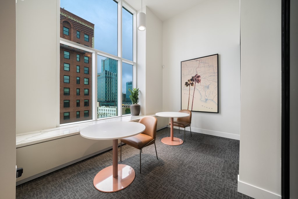 A room with a table and chairs and a picture on the wall.
