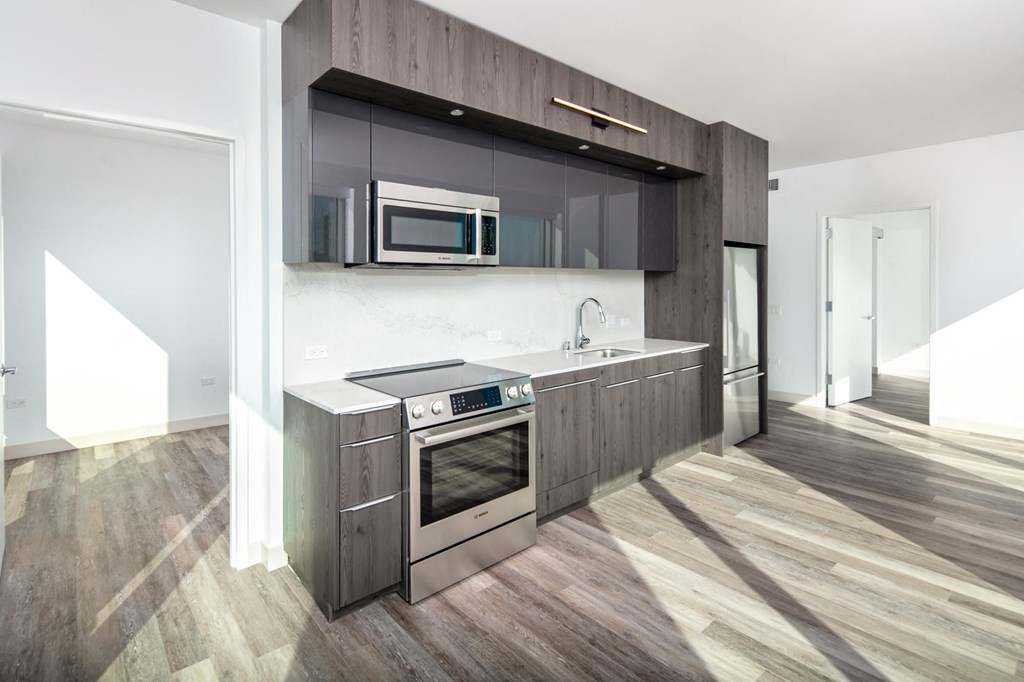 a kitchen with dark wood cabinets and stainless steel appliances