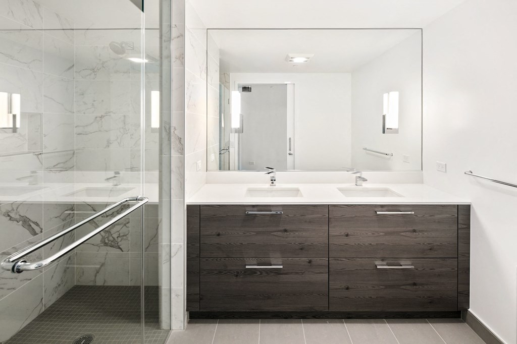 a bathroom with white walls and a glass shower stall