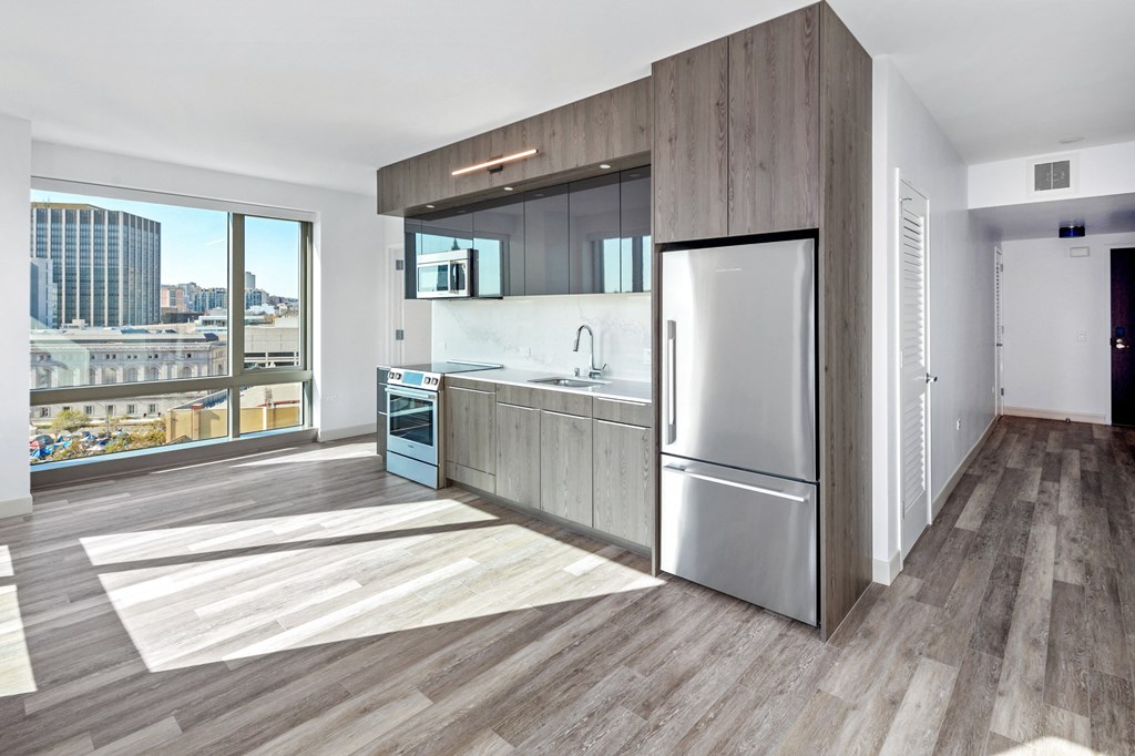 a kitchen with wood floors and stainless steel appliances