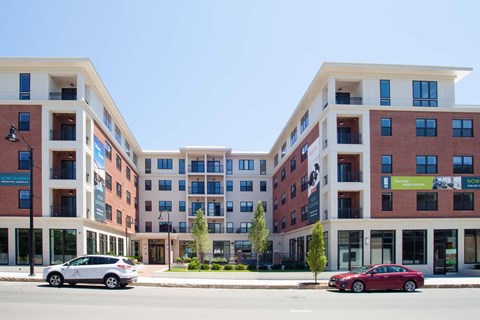 Two cars are parked in front of a building.