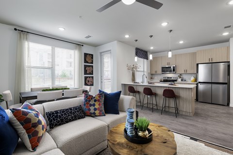 A modern living room with a grey sofa and a wooden coffee table.
