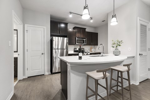 a kitchen with a large island with two stools