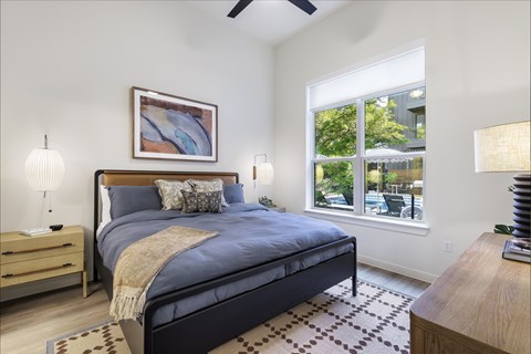 A bedroom with a large bed and a ceiling fan.
