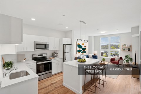 A modern kitchen with white cabinets and stainless steel appliances.