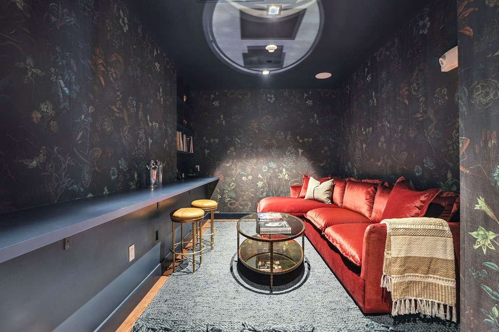 a living room with a red couch and a bar
