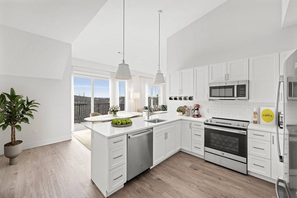 an open kitchen with white cabinets and a large island