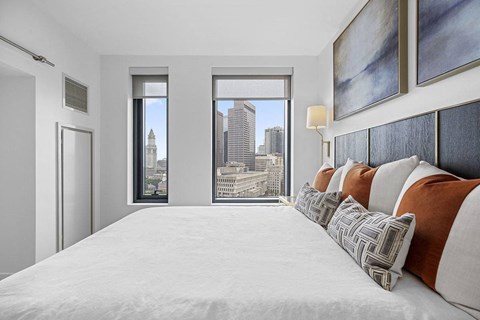 a bedroom with a large bed and a city view