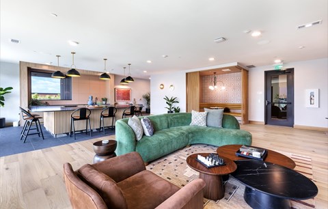 A modern living room with a green couch and brown chairs.