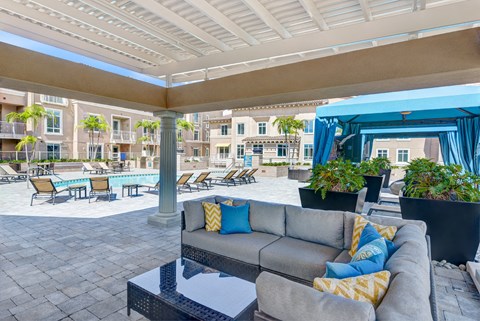 a lounge area with a couch and tables and a pool