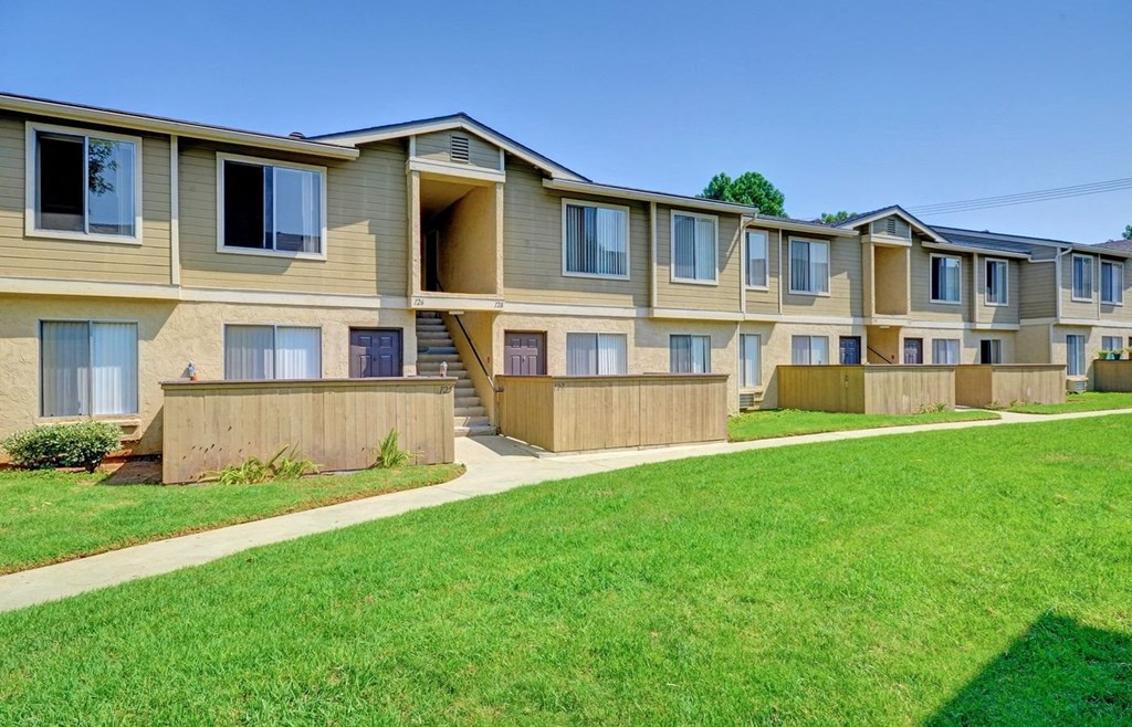 a row of town homes with a green lawn