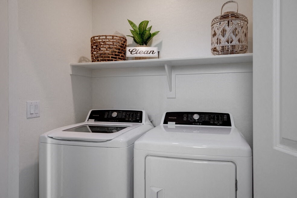 a small laundry room with two washers and a dryer
