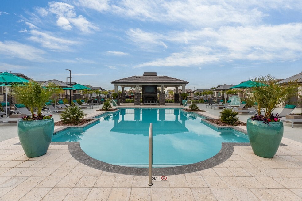 a swimming pool with a pool house and umbrellas at the resort