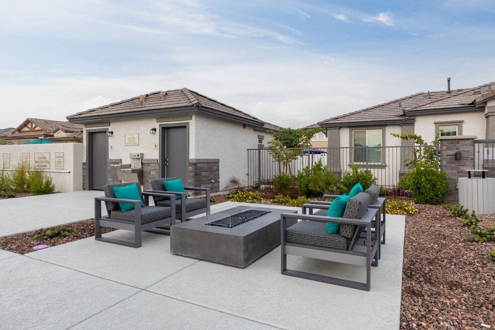 a patio with chairs and a fire pit in front of a house