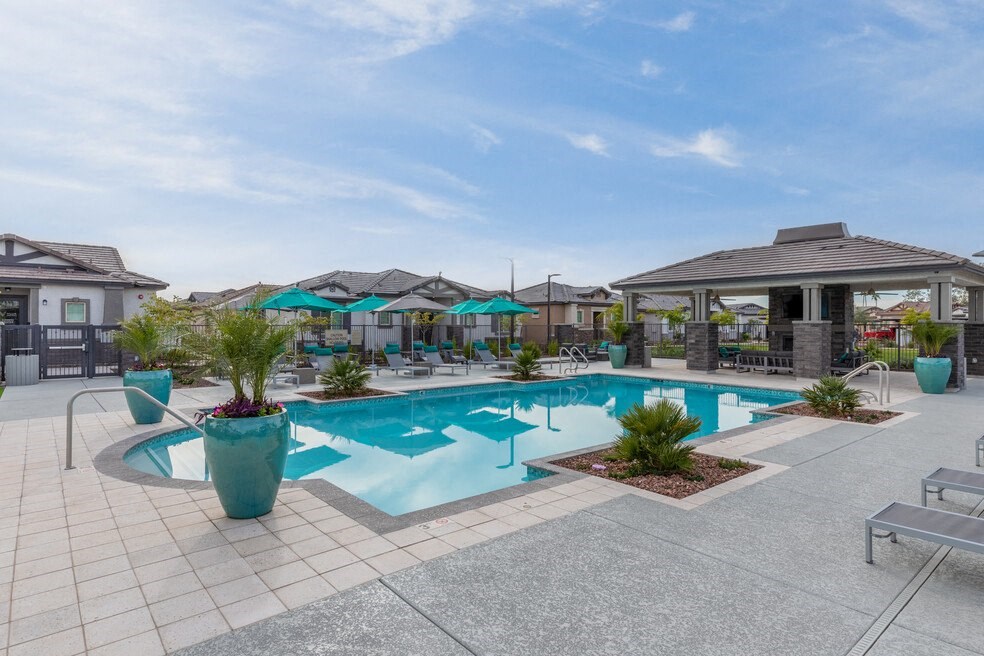 a swimming pool with chairs and umbrellas near a resort style pool