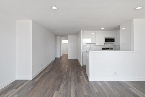 a bedroom with a medium sized bed and a kitchen with white cabinets
