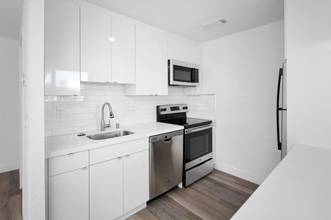 a kitchen with white cabinetry and stainless steel appliances