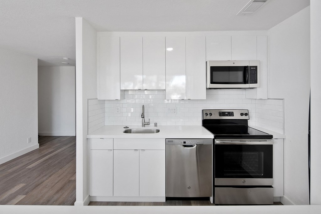 a kitchen with white cabinets and stainless steel appliances