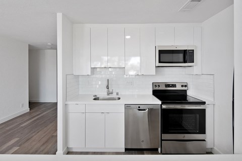 a kitchen with white cabinets and stainless steel appliances