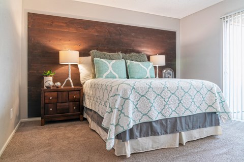 A bedroom with a bed and a wooden headboard at Westmount at Urban Trails, Mesa, 85202