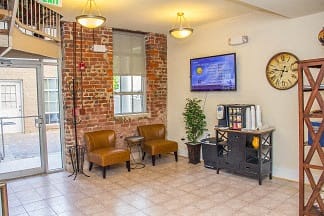 A room with a brick wall and a flat screen TV mounted on the wall.