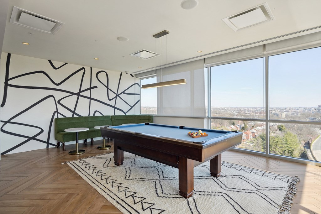 a room with a pool table and a large window