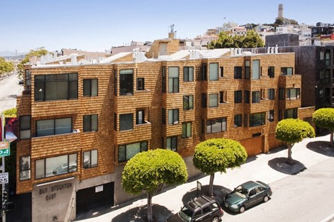 A brown building with green trees in front of it.