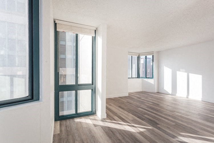 an empty room with white walls and wood floors