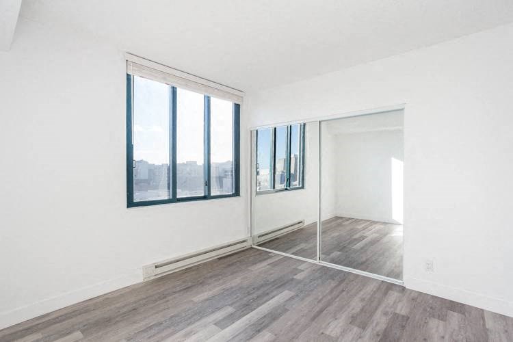 an empty room with white walls and a large window