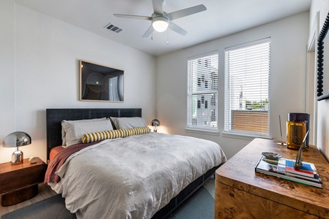 a bedroom with a large bed and a ceiling fan